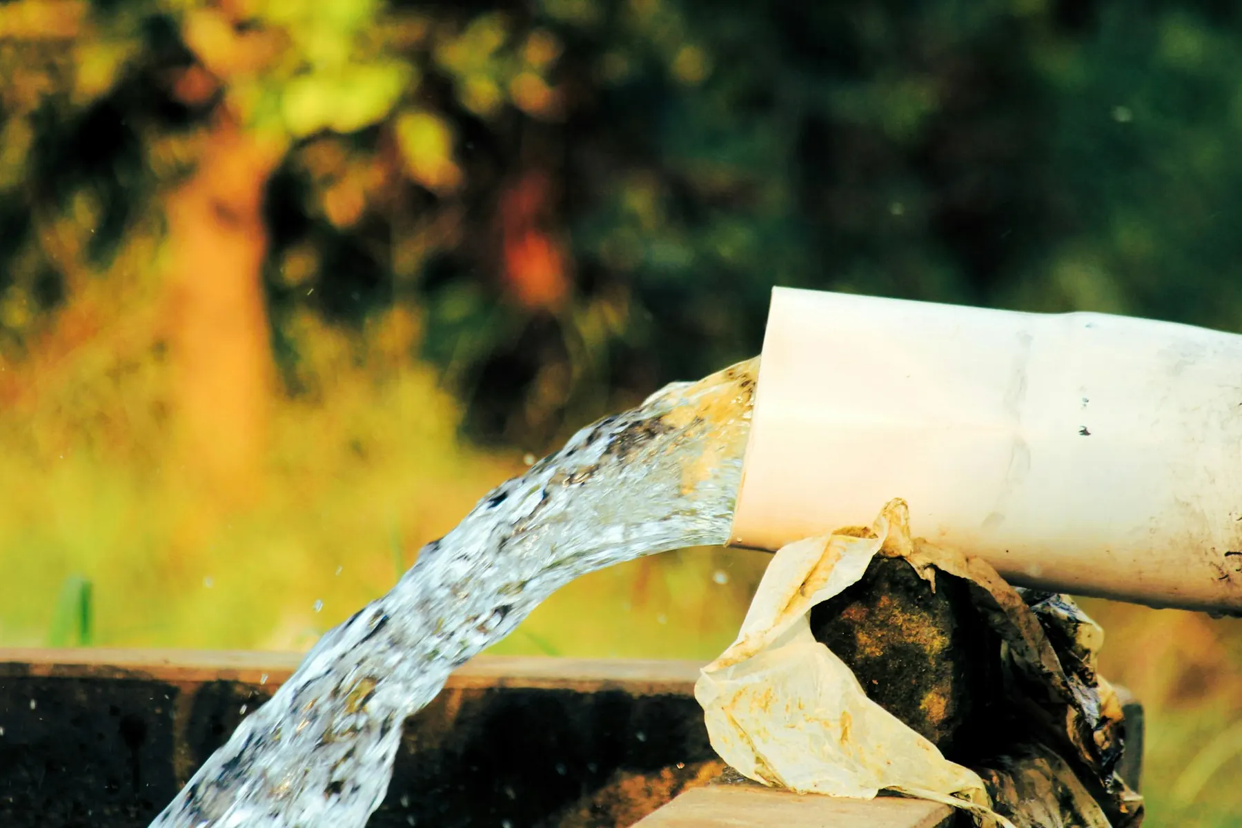 Clear water pouring from a white pipe